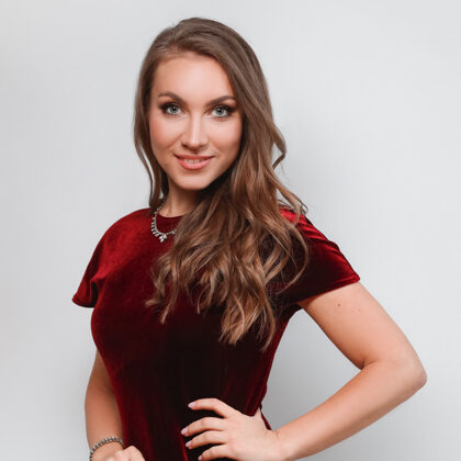 Portrait of soprano Annija Adamsone standing in a red dress