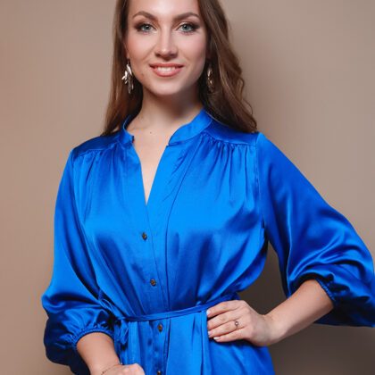 Portrait of soprano Annija Adamsone standing in a blue dress