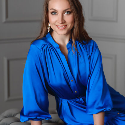 Portrait of soprano Annija Adamsone sitting in a blue dress