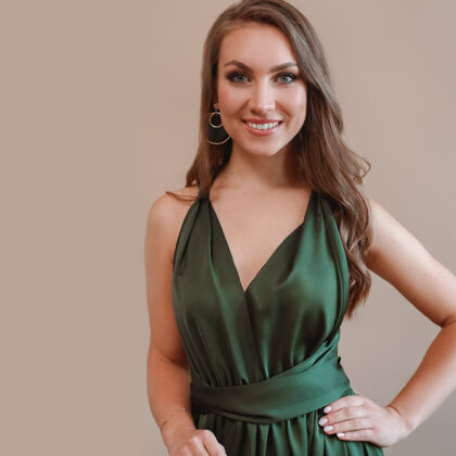 Portrait of soprano Annija Adamsone standing in a green dress