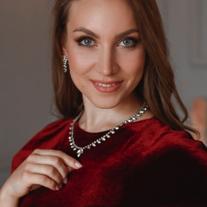 Close portrait of soprano Annija Adamsone in a red dress