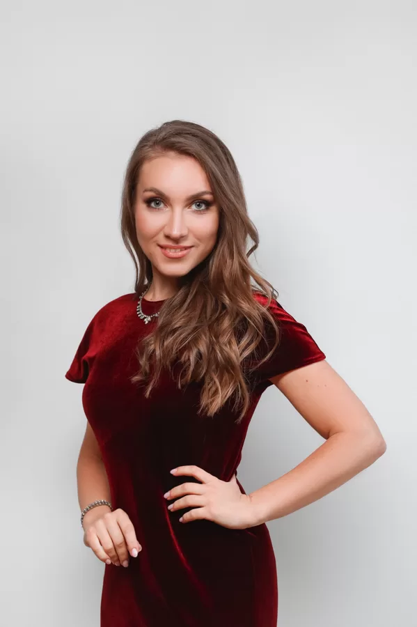 Portrait of soprano Annija Adamsone standing in a red dress