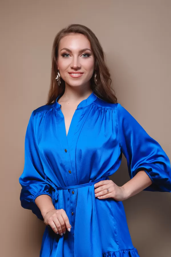 Portrait of soprano Annija Adamsone standing in a blue dress