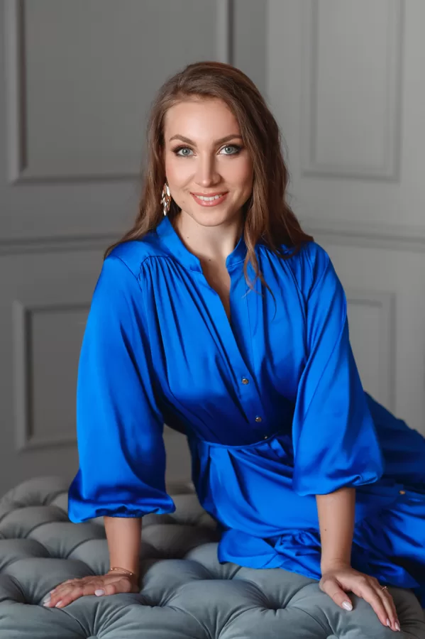 Portrait of soprano Annija Adamsone sitting in a blue dress