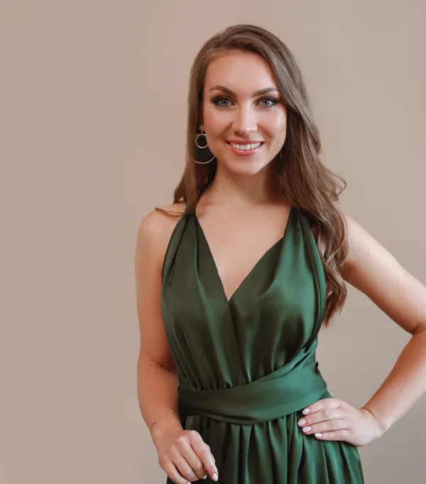 Portrait of soprano Annija Adamsone standing in a green dress