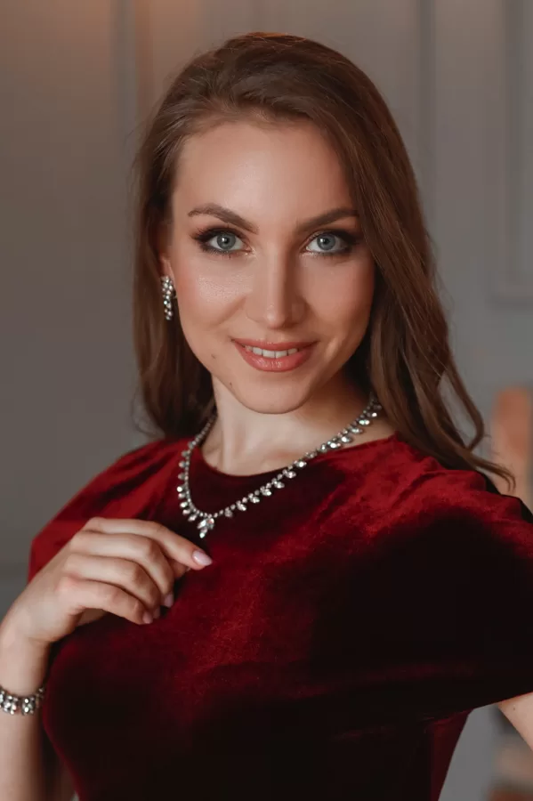Close portrait of soprano Annija Adamsone in a red dress