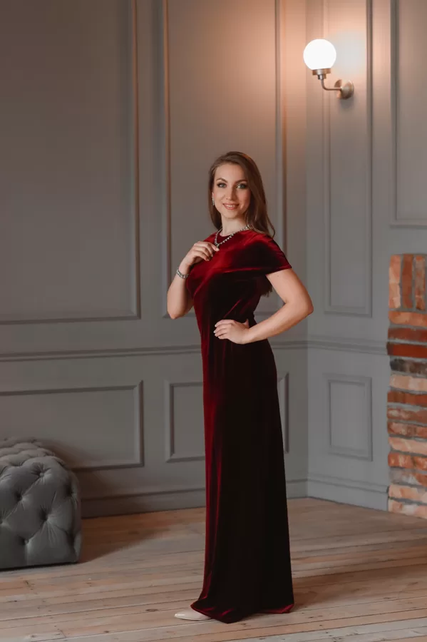 Portrait of soprano Annija Adamsone standing in a red dress